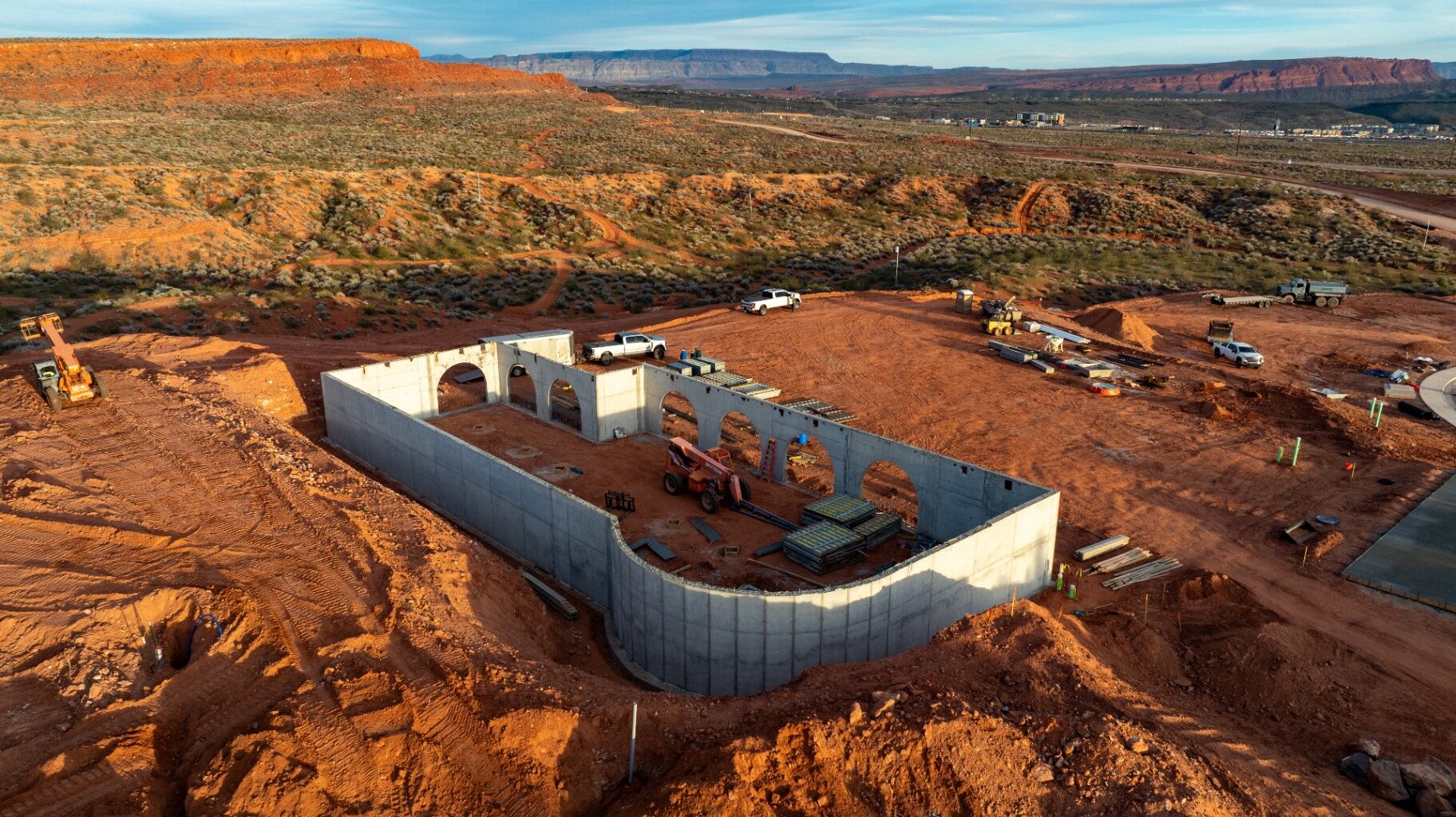 Aerial view of a concrete foundation under construction in Southern Utah, surrounded by red rock terrain and equipment